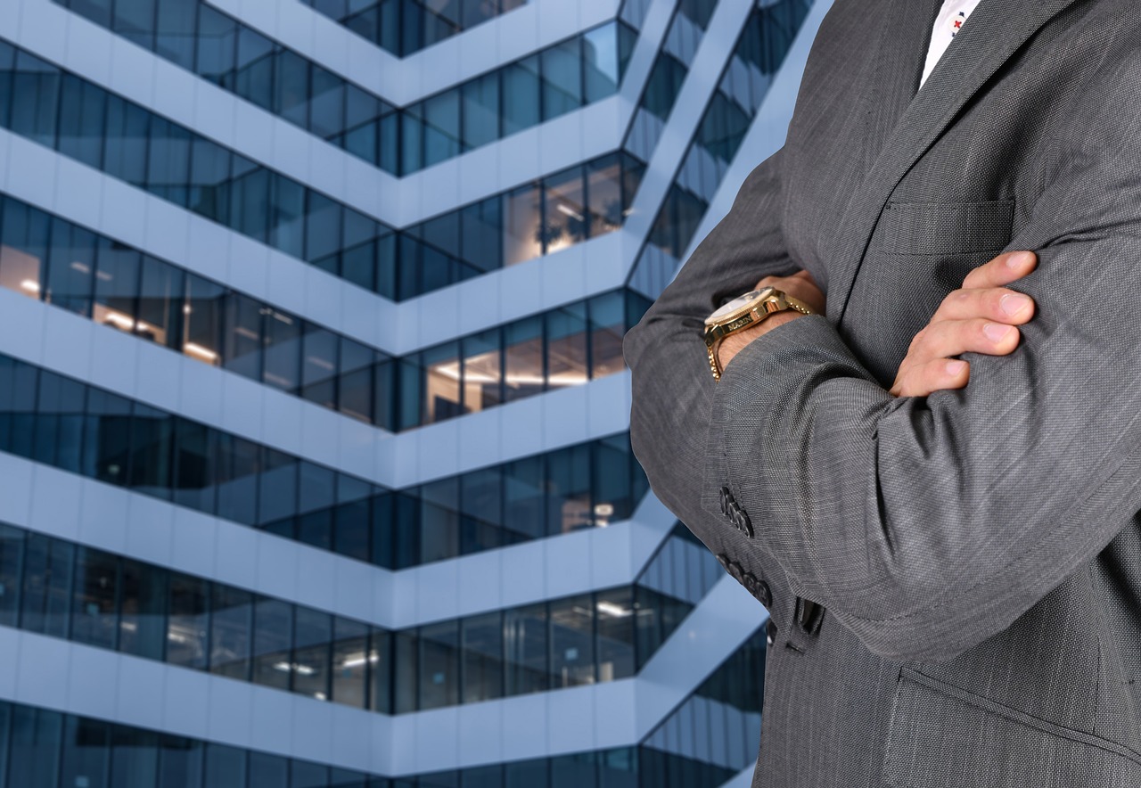 Persona con traje y un edificio corporativo en el fondo